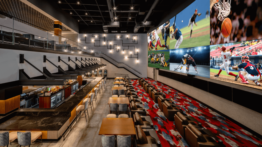 Spacious interior of The Nash Casino’s DraftKings Sportsbook featuring a full bar, stadium-style seating, and a massive multi-screen video wall showing live sports.